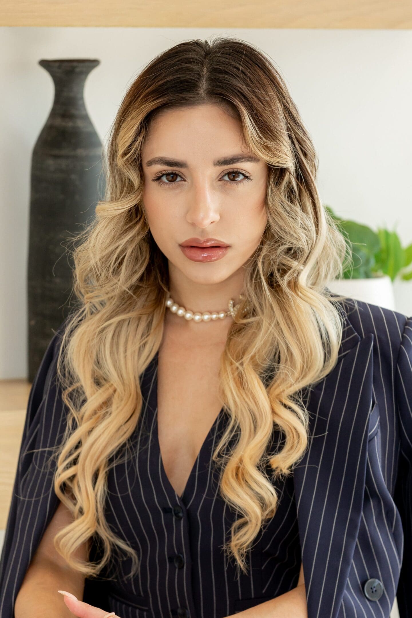 A woman with long blonde hair wearing a black and white striped shirt.