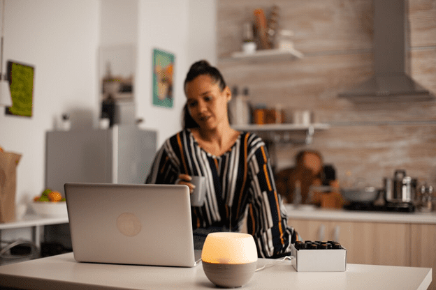 A woman sitting at her laptop on the counter