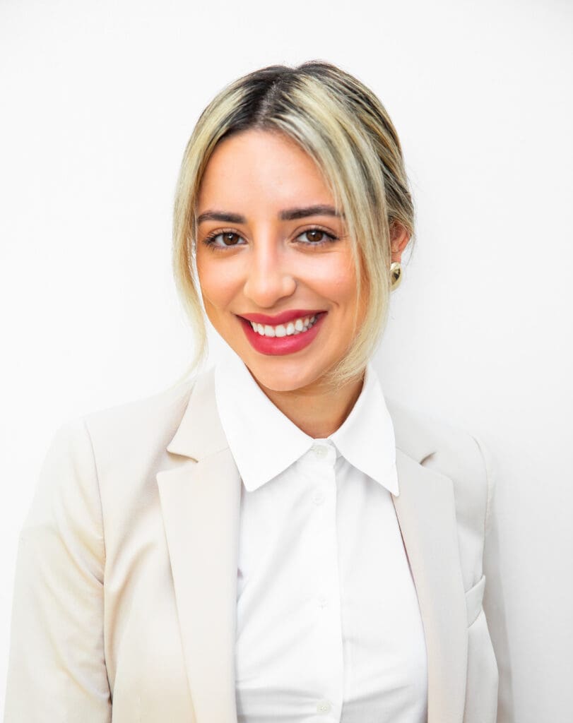 Smiling woman in professional attire with blonde hair.