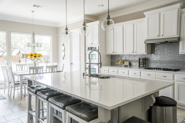 Bright modern kitchen with white cabinetry and island seating.
