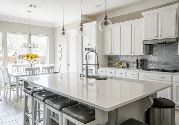 Bright modern kitchen with white cabinetry and island seating.